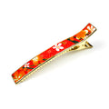 Grande pince cheveux crocodile avec décor fleurs de cerisier sur fond orangé